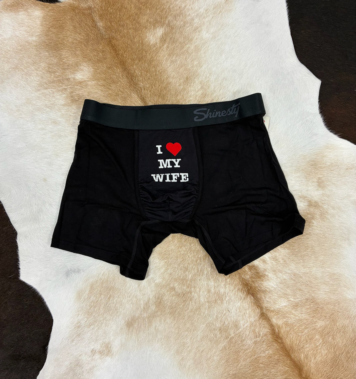 Black boxer briefs with 'I ❤️ MY WIFE' text on a cowhide rug