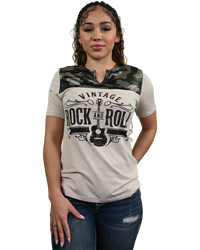 A woman modeling a short-sleeve t-shirt with a beige body, a green camouflage yoke, and a black 'Vintage Rock and Roll' graphic on the front, paired with blue jeans against a white background.