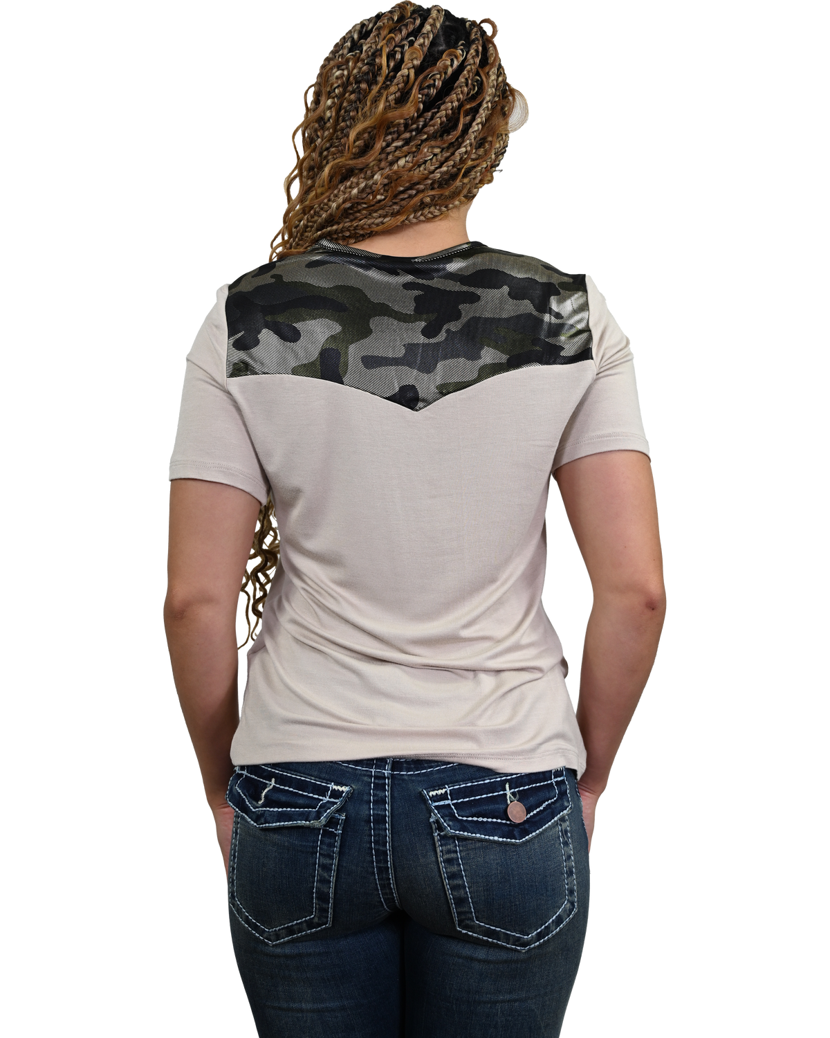 A woman viewed from behind wearing a short-sleeve t-shirt with a beige body and a dark green and black camouflage yoke across the shoulders, paired with dark blue jeans.