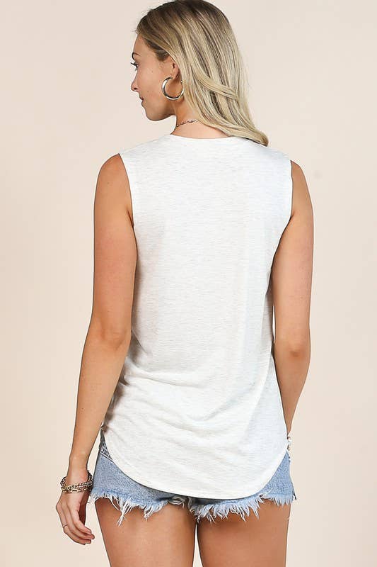 Woman wearing a white sleeveless top and denim shorts on a beige background
