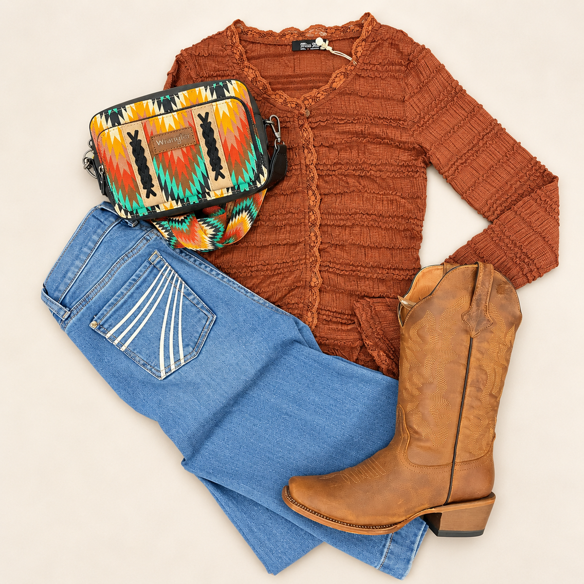 Flat lay with rust color sweater purse boots and jeans.