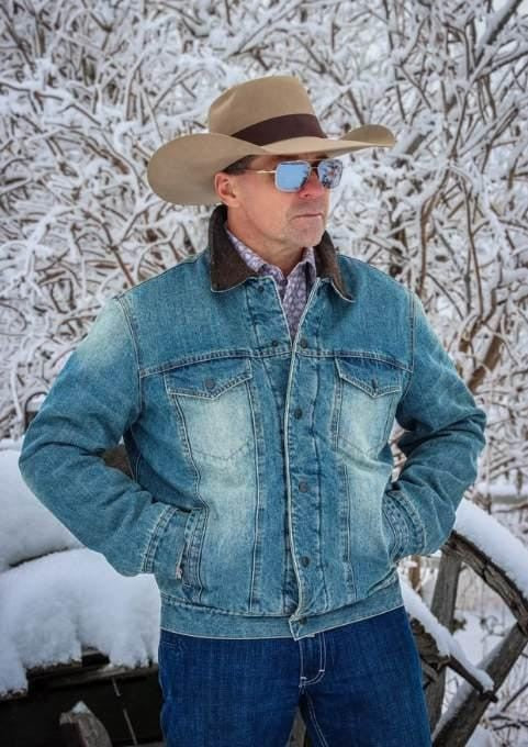 man in snowy scene wearing a denim jacket